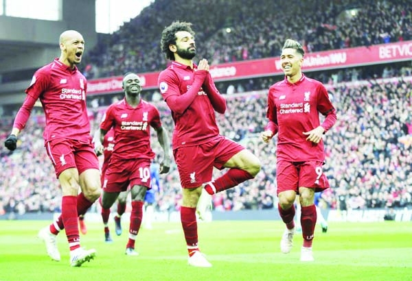 Liverpool's Egyptian midfielder Mohamed Salah (center) celebrates with teammates after scoring their second goal during the English Premier League football match between Liverpool and Chelsea at Anfield in Liverpool, North West England on Sunday.