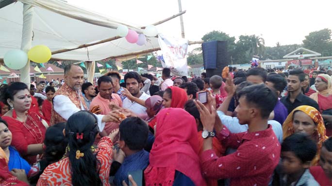 M A Latif MP greeting people by giving pitha marking the Pahela Baishakh on Sunday.