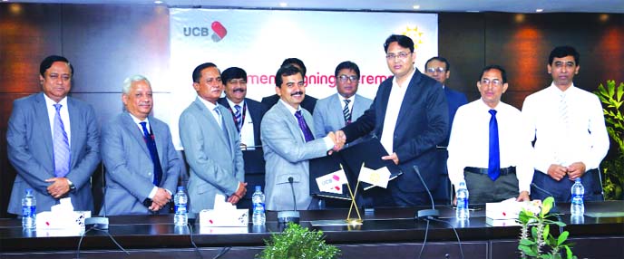 Subhash Chandra Das, chief financial officer of Sonali Bank Limited and A T M Tahmiduzzaman, Head of UCash of United Commercial Bank (UCB) Limited, exchanging an agreement signing document for collecting the E-Chalan and other fees and charges of differen