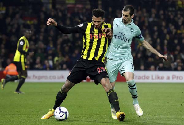 Arsenal's Henrikh Mkhitaryan (right) vies for the ball with Watford's Etienne Capoue during the English Premier League soccer match between Watford and Arsenal at Vicarage Road stadium in Watford, England on Monday.
