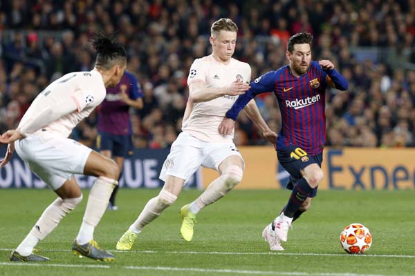 Barcelona forward Lionel Messi (right) runs with the ball past Manchester United's Scott McTominay (center) and Manchester United's Chris Smalling during the Champions League quarterfinal, second leg, soccer match between FC Barcelona and Manchester Uni