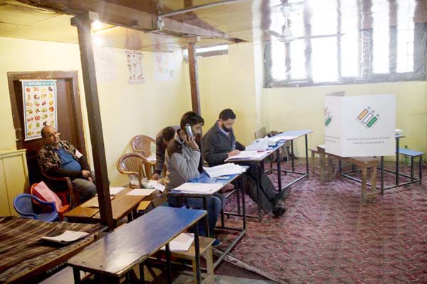 Election officers sit inside an empty polling station during the second phase of India's general elections, in Srinagar, Indian controlled Kashmir on Thursday.