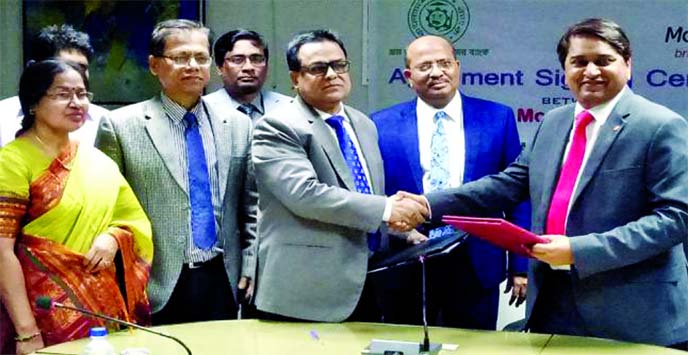 Md. Shahidul Islam, GM (Operation & Planning) of Bangladesh Krishi Bank (BKB) Limited and SA Yogesh Sangle, head of MoneyGram APAC, exchanging an agreement signing documents to Taka Drawing Arrangement (TDA) at the Bank's head office in the city on Wedne