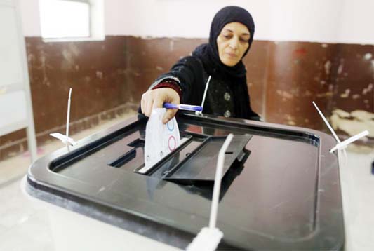 A voter casts her ballot on constitutional amendments during the first day of three-day voting at a polling station in Cairo, Egypt on Saturday.