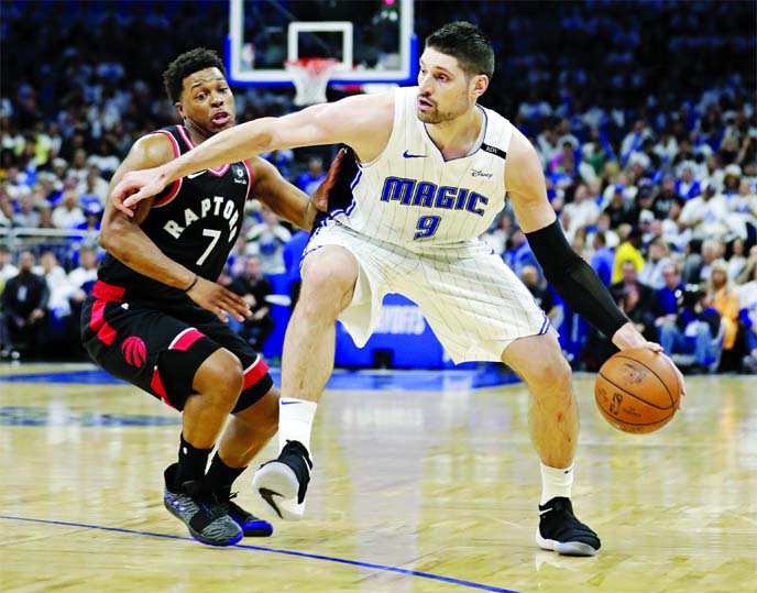 Orlando Magic's Nikola Vucevic (9) moves the ball against Toronto Raptors' Kyle Lowry (7) during the second half in Game 3 of a first-round NBA basketball playoff series in Orlando, Fla on Friday.