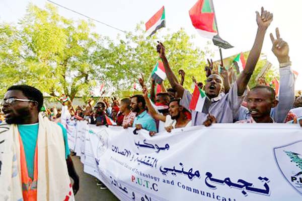 Sudanese demonstrators wave national flags as they attend a mass anti-military protest outside the Defence Ministry in Khartoum on Sunday.