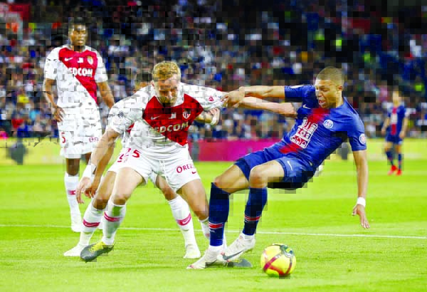 PSG's Kylian Mbappe (right) is challenged by Monaco's Kamil Glik in the French League One soccer match between Paris-Saint-Germain and Monaco at the Parc des Princes stadium in Paris on Sunday.