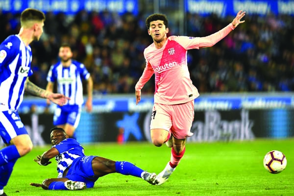 Barcelona mildfider Carles Alena (right) is tacked by Deportivo Alaves Mubarak Wakaso during a Spanish La Liga soccer match between Deportivo Alaves and FC Barcelona at the Medizorrosa stadium in Vitoria, Spain on Tuesday.