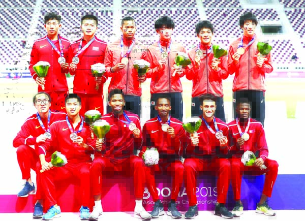 Athletes from team Japan (standing right) China (standing and seated left) and Qatar (bottom right) celebrate with their gold, silver and bronze medals respectively for the men's 4x400 relay race at the Asian Athletics Championships in Doha, Qatar on Wed