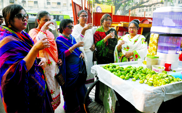 To cool themselves a group of women taking lemon sharbat, allegedly made of impure water from a street vendor amid Thursday's sweltering heat. This photo was taken from in front of Jatiya Press Club.