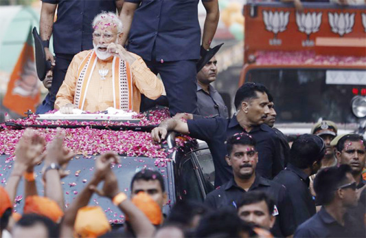 Indian Prime Minister Narendra Modi is covered in flower petals during a road show in Varanasi, India on Thursday.