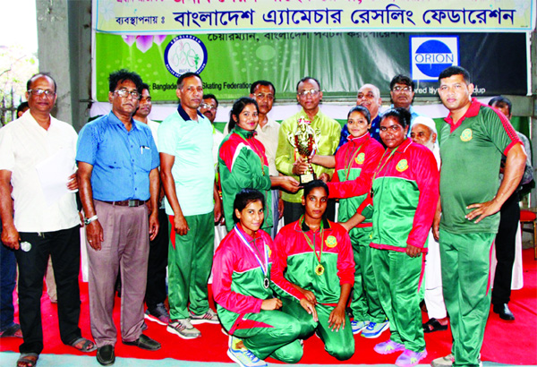Members of Bangladesh Army, the champions in the Women's Division of the 8th Services Wrestling Competition with the guests and officials of Bangladesh Amateur Wrestling Federation pose for a photo session at the Sheikh Russel Roller Skating Complex on T