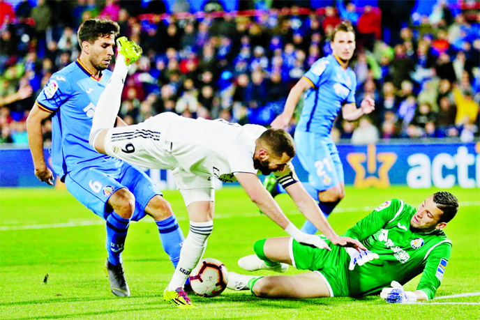 Getafe's goalkeeper David Soria (right) saves on an attempt to score by Real Madrid's Karim Benzema (second left) during a Spanish La Liga soccer match between Getafe and Real Madrid at the Alfonso Perez stadium in Getafe, Spain on Thursday.