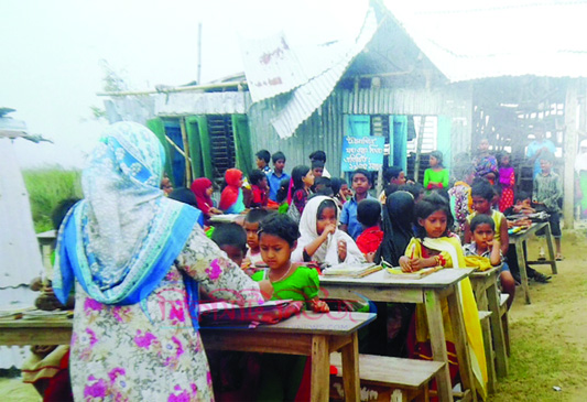 RAJSHAHI: Students of Choumadiya Government Primary School at Bagha Upazila in Rajshahi attending their classes under open sky as their school has been vandalised due to recent nor'wester . This snap was taken on Friday.