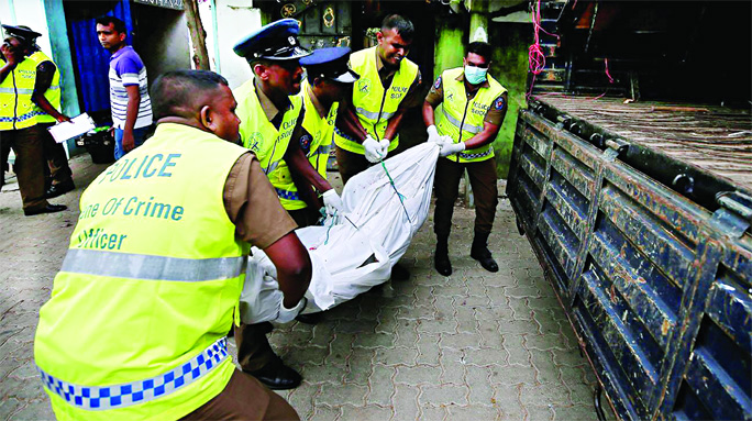 Police officers carry the body at the site of an overnight gun battle, between troops and suspected Islamist militants, on the east coast of Sri Lanka in Kalmunai on Saturday.