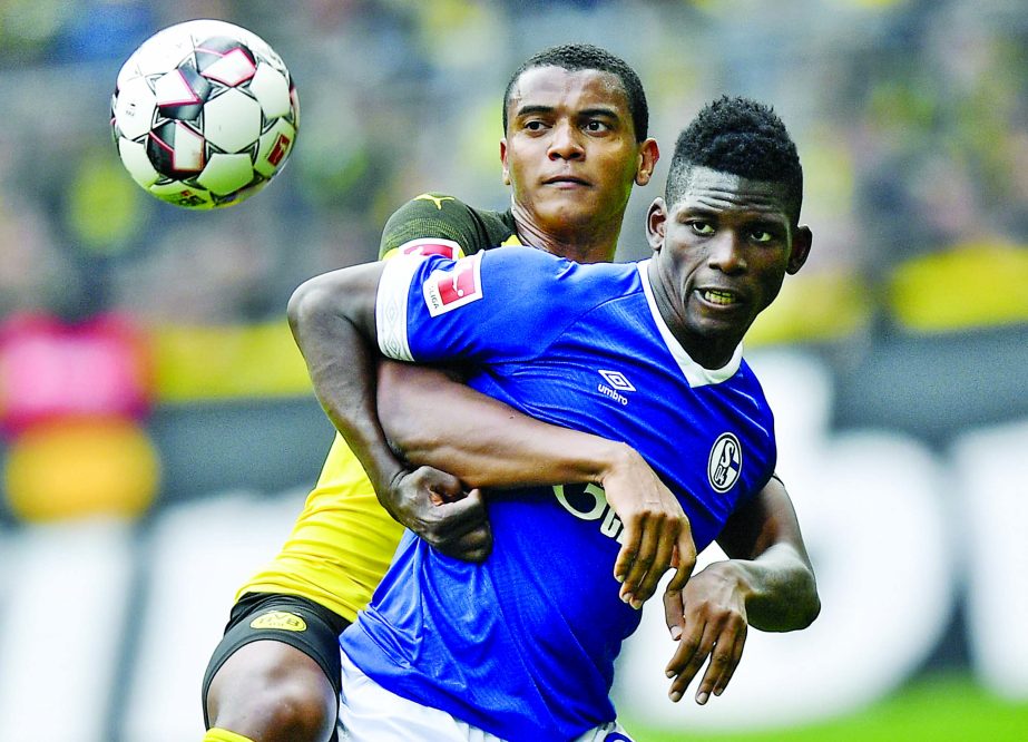 Schalke's Breel Embolo (right) and Dortmund's Manuel Akanji challenge for the ball during the German Bundesliga soccer match between Borussia Dortmund and FC Schalke 04 in Dortmund, Germany on Saturday.