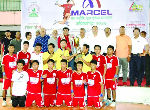 Members of Bandarban DSA, the champions in the Marcel 4th National Youth (Men's) Handball Competition with the guests and officials of Bangladesh Handball Federation pose for photograph at the Shaheed (Captain) M Mansur Ali National Handball Stadium on T