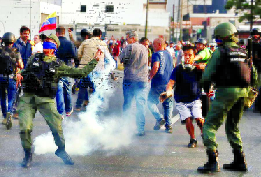 A military member throws a tear gas canister near the Generalisimo Francisco de Miranda Airbase "La Carlota", in Caracas, Venezuela on Tuesday. Internet photo