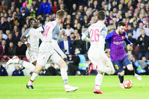 Barcelona's Lionel Messi (right) plays the ball past Liverpool's Andy Robertson (second right), Liverpool's Jordan Henderson (second left) and Liverpool's Sadio Mane during the Champions League semifinal, first leg, soccer match between FC Barcelona a