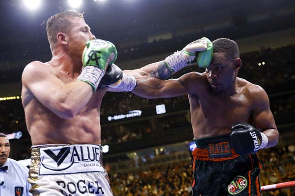Canelo Alvarez (left) of Mexico, hits Daniel Jacobs during a middleweight title boxing match at Las Vegas on Saturday.
