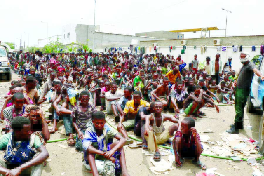 Ethiopian migrants, stranded in war-torn Yemen, sit on the ground of a detention site pending repatriation to their home country, in Aden, Yemen.