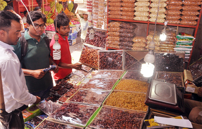 Customers buying dates at Riazuddin Bazar on the first day of Ramzan on Tuesday.