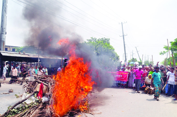 Latif Bawani and Karim Jute mills workers blocked the road and set woodlog on fire near Demra Staff Quarter in city as part of their agitation for 6th consecutive day on Saturday for implementation of Wage Commssion Award and meeting other 9 point demand