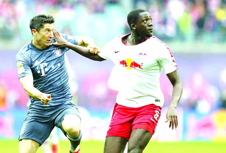 Bayern forward Robert Lewandowski (left) fights for the ball with Leipzig's Ibrahima Konate during the German Bundesliga soccer match between Leipzig and Bayern Munich at the Red Bull Arena stadium in Leipzig, Germany on Saturday.