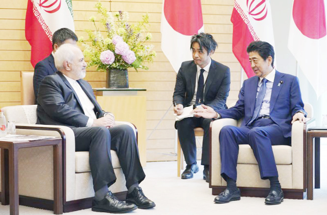 Iranian Foreign Minister Mohammad Javad Zarif, left, and Japanese Prime Minister Shinzo Abe, right, speak at Abe's official residence in Tokyo on Thursday.