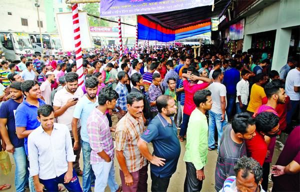 Home-bound people are seen in a long queue to purchase advance bus tickets to celebrate Eid festival with their near and dear ones. This photo was taken from Gabtali Bus Terminal on Friday.