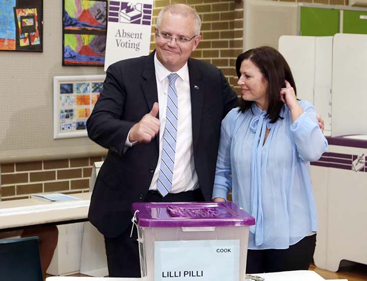 Australian Prime Minister Scott Morrison, left, gestures while holding his wife, Jenny, after casting his ballot in a federal election in Sydney, Australia on Saturday.