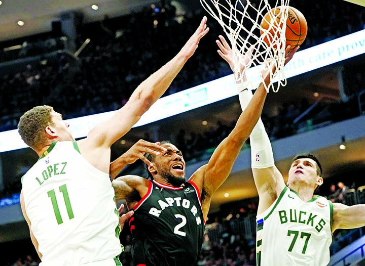 Toronto Raptors' Kawhi Leonard shoots between Milwaukee Bucks' Brook Lopez and Ersan Ilyasova during the second half of Game 2 of the NBA Eastern Conference basketball playoff finals in Milwaukee on Friday. The Bucks won 125-103 to take a 2-0 lead in th