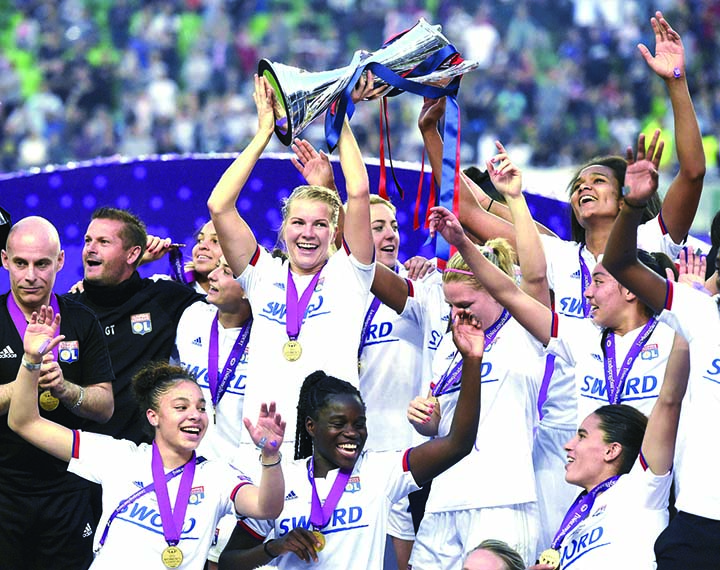 Players of Olympique Lyon celebrate with the trophy after the women's soccer UEFA Champions League final match between Olympique Lyon and FC Barcelona at the Groupama Arena in Budapest, Hungary on Saturday. Lyon defeated Barcelona by 4-1.