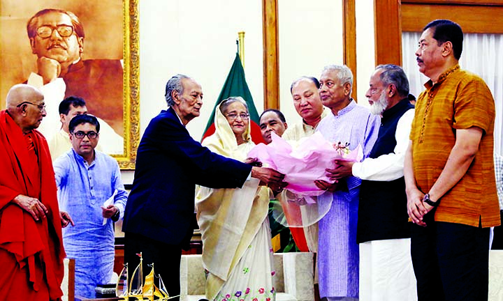 Prime Minister Sheikh Hasina being greeted with bouquet by the leaders of Buddhist community at Ganobhaban on Monday on the occasion of Buddha Purnima , a religious festival of the community. BSS photo