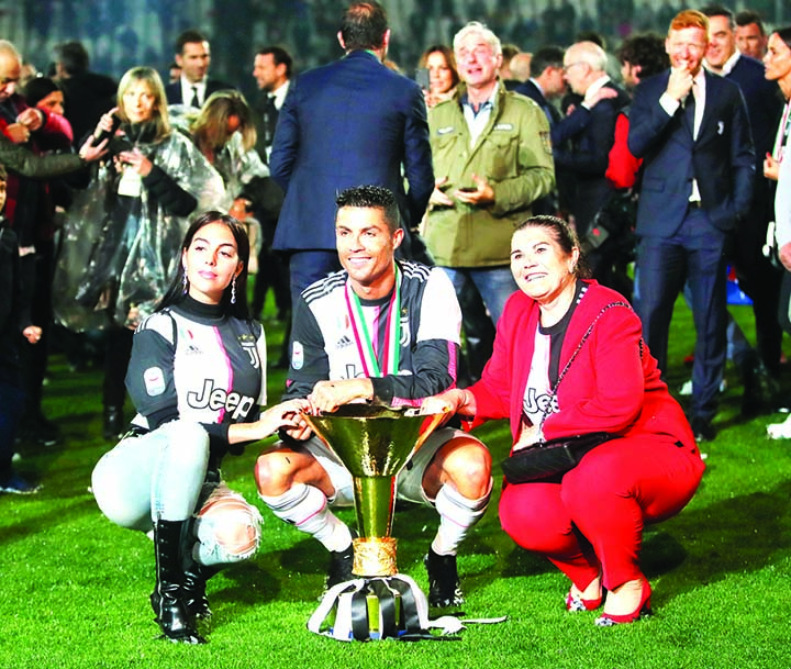 Juventus' Cristiano Ronaldo (center) is flanked by his girlfriend Georgina (left) and his mother Dolores Aveiro (right) after winning the Serie A soccer title trophy, at the Allianz Stadium, in Turin, Italy on Sunday.