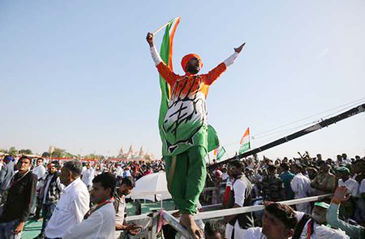 A supporter of India's main opposition Congress party shouts slogans as he waves the party flag during a public meeting in Gandhinagar, Gujarat.