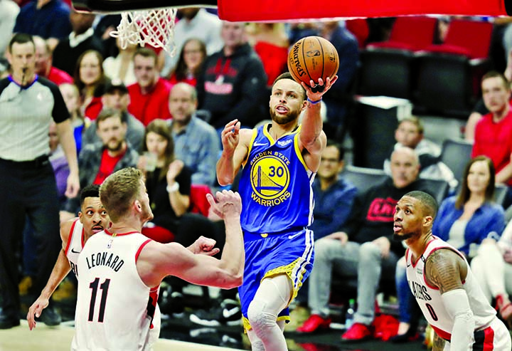 Golden State Warriors guard Stephen Curry (30) puts up a shot against Portland Trail Blazers forward Meyers Leonard (11) during the second half of Game 4 of the NBA basketball playoffs Western Conference finals in Portland, Ore on Monday. The Warriors wo
