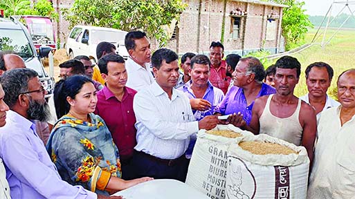 Natore Deputy Commissioner Mohammad Shahriaz purchasing paddy directly from the farmers in Kafuria area of Sadar upazila on Tuesday.