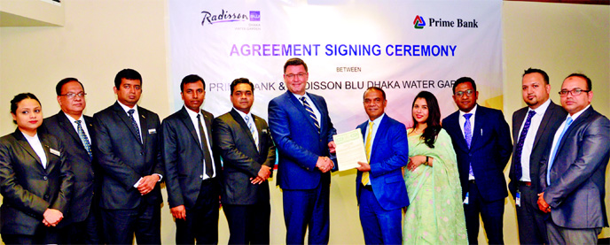 Zubayer Ershad, Head of Consumer Banking Business of Prime Bank Ltd and Alexander Haeusler, General Manager of Radisson Blu Dhaka Water Garden, exchanging an agreement signing document at a hotel in the city recently. Shaila Abedin, Head of Segments of t