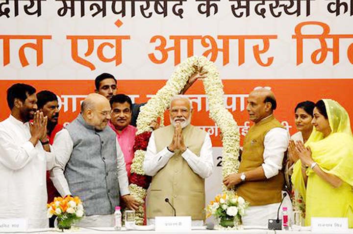 India's Prime Minister Narendra Modi gestures as he is presented with a garland during a thanksgiving ceremony by Bharatiya Janata Party (BJP) leaders to its allies at the party headquarters in New Delhi on Tuesday.