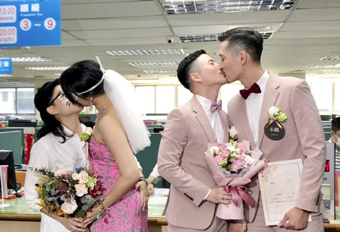 Two same-sex couples seal their legal marriage with a kiss at the registration office in Xingyi District in Taipei, Taiwan on Friday.