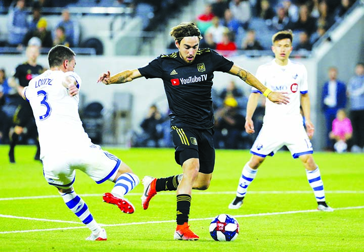 Los Angeles FC (LAFC) midfielder Andre Horta (center) vies with Montreal Impact defender Daniel Lovitz (3) for the ball during the second half of an MLS soccer match in Los Angeles on Friday. LAFC won 4-2.