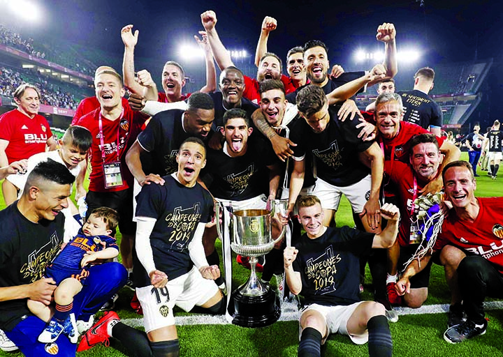 Valencia players celebrate with the trophy after winning the Copa del Rey soccer match final between Valencia CF and FC Barcelona at the Benito Villamarin stadium in Seville, Spain on Saturday.