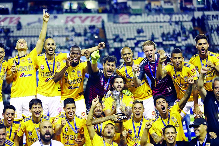 Tigres players hold the trophy aloft as they celebrate their victory in the final Mexico soccer league championship match in Leon, Mexico on Sunday.
