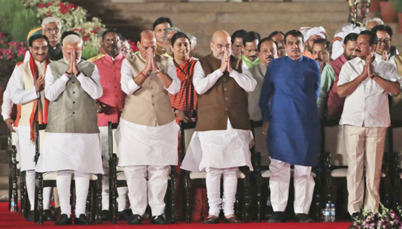 Indian Prime Minister Narendra Modi, (left) with newly sworn his Cabinet Ministers greet the invitees at the end of the swearing in ceremony at the forecourt of Presidential Palace in New Delhi, India, on Thursday.