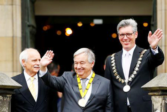 Charlemagne Prize (Karlspreis) recipient, United Nations Secretary-General Antonio Guterres, waves from the town hall balcony, flanked by former Mayor Juergen Linden and Mayor Marcel Philipp during the ceremony in Aachen, Germany on Thursday.