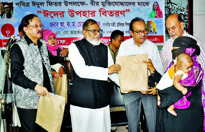 Liberation Affairs Minister AKM Mozammel Huq distributing Eid gifts to distressed people on behalf of National FF Foundation at the premises of the Ministry yesterday .