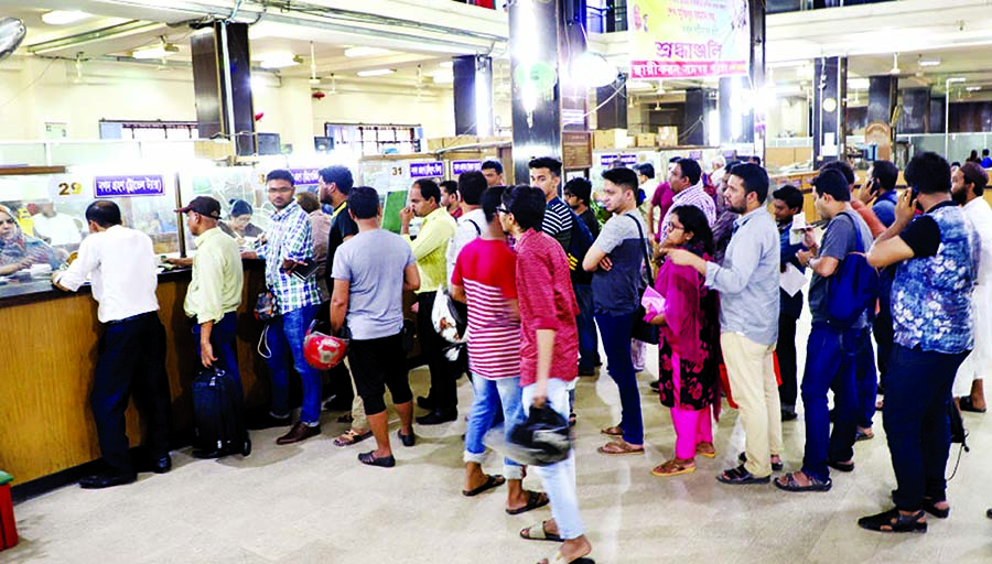 Clients are in long queue in bank counter to draw money from their accounts. This photo was taken from a bank counter in city's Motijheel area on Monday.