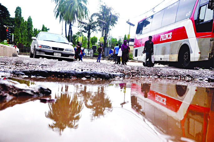 A portion of road in front of Kamalapur Bus Depot is in dilapidated condition as a big pothole being developed due to a little downpour in city, causing sufferings to commuters. This photo was taken on Friday.