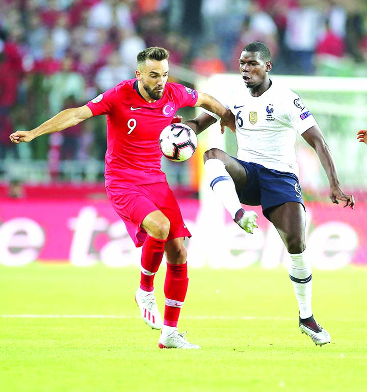 Turkey's forward Kenan Karaman (left) is challenged by France's midfielder Paul Pogba during the Euro 2020 Group H qualifying soccer match between Turkey and France in Konya, Turkey on Saturday.